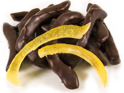 Pieces of candied, glace lemon peel, enrobed in dark chocolate sit together.