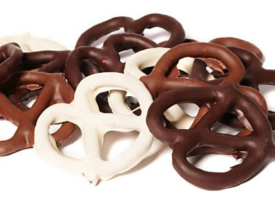 Thin pretzels, enrobed in milk and dark chocolate, are stacked together.