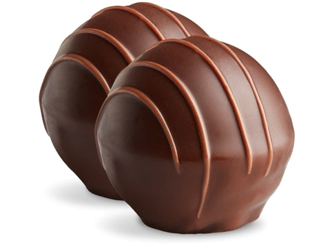 Two mocha truffles sit side by side. They are enrobed in dark chocolate with milk chocolate drizzles in straight lines on top. 
