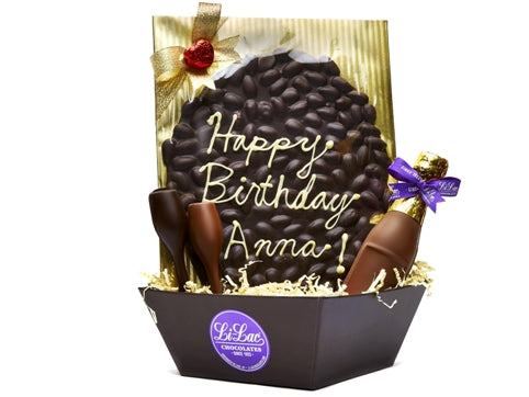 A gift basket with 7"chocolate champagne bottle, chocolate molded champagne flutes and an oval of almond bark with a birthday greeting piped onto it.