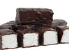 Thick bars of marshmallow enrobed in dark chocolate are lined up together. The bars are cut so that you can see the soft white marshmallow inside.