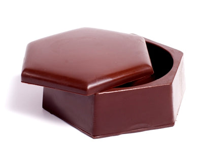 A two piece hexagonal shaped chocolate molded pill box. The lid can be opened.