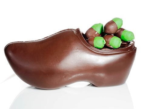 A molded chocolate Dutch-style wooden shoe is filled with bright green marzipan that is molded into bite-sized acorn shapes. The acorn “cap” is made by dipping the marzipan into 72% dark dairy-free chocolate.