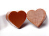 Two molded chocolate hearts have a cross hatch texture molded into the surface.