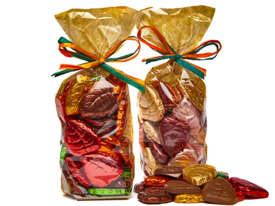 Cellophane bags are filled with foil wrapped chocolate molded leaves. They are in autumnal colors. 