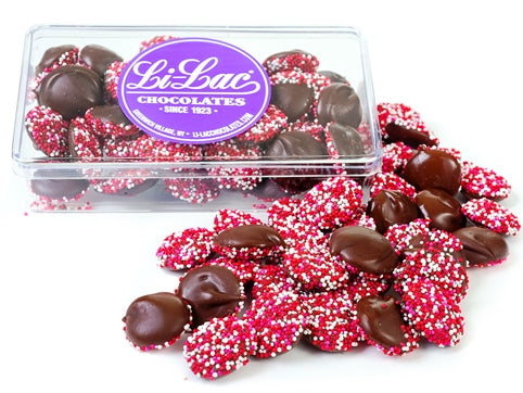Nonpareils in a clear acrylic box, they are decorated with red, pink and white nonpareils candies.