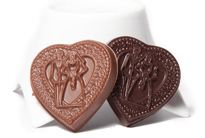 Two molded chocolate hearts have a Bride and Groom embossed on the front inside the textured chocolate heart.